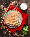 Doner kebab with meat cutlets and vegetables on a plate with a red napkin and garlic sauce On wooden rustic background, top view Royalty Free Stock Photo