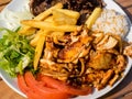 Doner kebab on the plate with french fries, tomatoes, rice, onion and salad. Grilled chicken and lamb meat with vegetables.