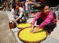 ethnic women treated with rice on a street Zhaoxing Village. Yellow rice is found in large wicker baskets. Zhaoxing Town