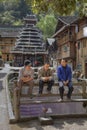minority village, three Chinese rest on bench, Guizhou, Chi
