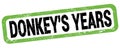 DONKEY`S YEARS text written on green-black rectangle stamp Royalty Free Stock Photo