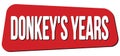 DONKEY`S YEARS text on red trapeze stamp sign Royalty Free Stock Photo