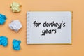 For donkey years - english idiom hand lettering on wooden blocks Royalty Free Stock Photo