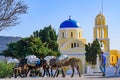 Donkeys carrying cargo in front of the yellow church in Oia, Santorini, Greece Royalty Free Stock Photo