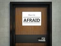 Dont be afraid sign hanging on a office door