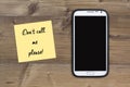 Dont call me please message, smart phone and sticky note on wood