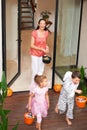 Dont eat them all at once. two happy kids leaving a house on Halloween with buckets of treats. Royalty Free Stock Photo
