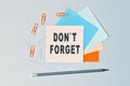 DonT Forget - text on sticky note paper on gray background. Closeup of a personal agenda. Top view Royalty Free Stock Photo
