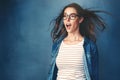 Dont forget to blow your own mind. Studio shot of a young woman with air being blown in her face against a blue