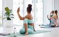 Dont forget to stretch your spine. Full length shot of an unrecognisable woman leading a yoga class in her studio and