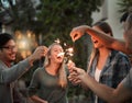Dont get burned guys. a group of cheerful young friends having fun with sparklers together outside at night. Royalty Free Stock Photo