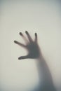 Dont get trapped in debt. Defocussed shot of a single hand reaching out against a plain background. Royalty Free Stock Photo