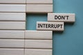 Dont interrupt symbol. Concept word Dont interrupt on wooden blocks. Beautiful grey green background. Business and Dont interrupt