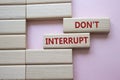 Dont interrupt symbol. Concept word Dont interrupt on wooden blocks. Beautiful pink background. Business and Dont interrupt