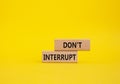 Dont interrupt symbol. Concept word Dont interrupt on wooden blocks. Beautiful yellow background. Business and Dont interrupt