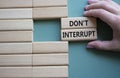 Dont interrupt symbol. Concept word Dont interrupt on wooden blocks. Businessman hand. Beautiful grey green background. Business