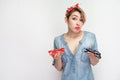 Dont know. Portrait of sadness young woman in casual blue denim shirt with makeup, red headband standing, holding two pairs of