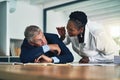 Dont let me catch you again. a businesswoman waking her colleague as he sleeps at his desk. Royalty Free Stock Photo