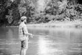 Dont look back. experienced fisher in water. fisherman show fishing technique use rod. man catching fish. mature man fly