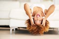 Dont look for happiness, create it. a young woman lying upside down on her couch. Royalty Free Stock Photo