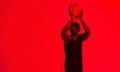 Dont miss your shot in life. Red filtered shot of a young sportsman posing with a basketball in the studio.