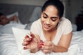 Dont underestimate the power of red nail polish. a beautiful young woman applying nail polish to her nails. Royalty Free Stock Photo