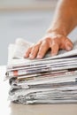 Dont waste paper. Shot of a hand on top of a stack of newspapers. Royalty Free Stock Photo
