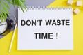 Dont Waste Time written with alarm clock and Notebook on yellow background. Business concept