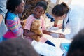 Dont worry, it doesnt hurt. volunteer nurses giving checkups to underprivileged kids.