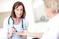 Dont worry, this wont hurt a bit. Mature nurse checking an elderly patients blood sugar levels with a prick to the Royalty Free Stock Photo