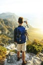 Dont you wish you were here. a young man taking selfies while hiking up a mountain.