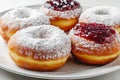 Donut berliner on white plate, Sufgania with powdered shugar and jam