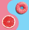 Donut on a blue background and pink grapefruit.