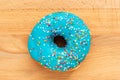 Donut blue with sprinkles isolated on wooden background Royalty Free Stock Photo