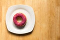 Donut with blueburry topping in white plate on wood background Royalty Free Stock Photo