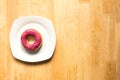 Donut with blueburry topping in white plate on wood background Royalty Free Stock Photo