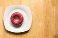 Donut with blueburry topping in white plate on wood background Royalty Free Stock Photo