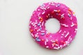 Donut coated with a pink frosting and sprinkles of different col Royalty Free Stock Photo