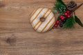 Striped Donut in glaze and festive pine branch on wooden natural background