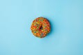 Donut glazed with sprinkles on a blue background. Modern flat lay photo pattern in pop art style, party food.