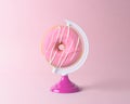 Donut on a globe stand on pastel pink background. Minimal concept Royalty Free Stock Photo