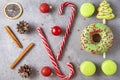 Donut with green icing, caramel, red Christmas balls, Christmas tree, cinnamon sticks, cones,  green French macaroon cookies, Royalty Free Stock Photo