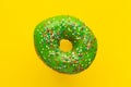 Donut green with sprinkles isolated on yellow background, close-up Royalty Free Stock Photo