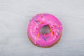 Donut with pink glaze on white wooden background Royalty Free Stock Photo