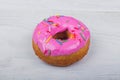 Donut with pink glaze on white wooden background Royalty Free Stock Photo