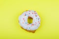 Donut with pink glaze on a yellow background