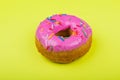 Donut with pink glaze on a yellow background Royalty Free Stock Photo