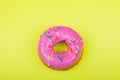 Donut with pink glaze on a yellow background Royalty Free Stock Photo