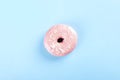 Donut with pink icing and coconut pastry topping on blue background. Top view Royalty Free Stock Photo