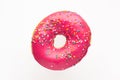 Donut pink with sprinkles isolated on white background, close-up Royalty Free Stock Photo